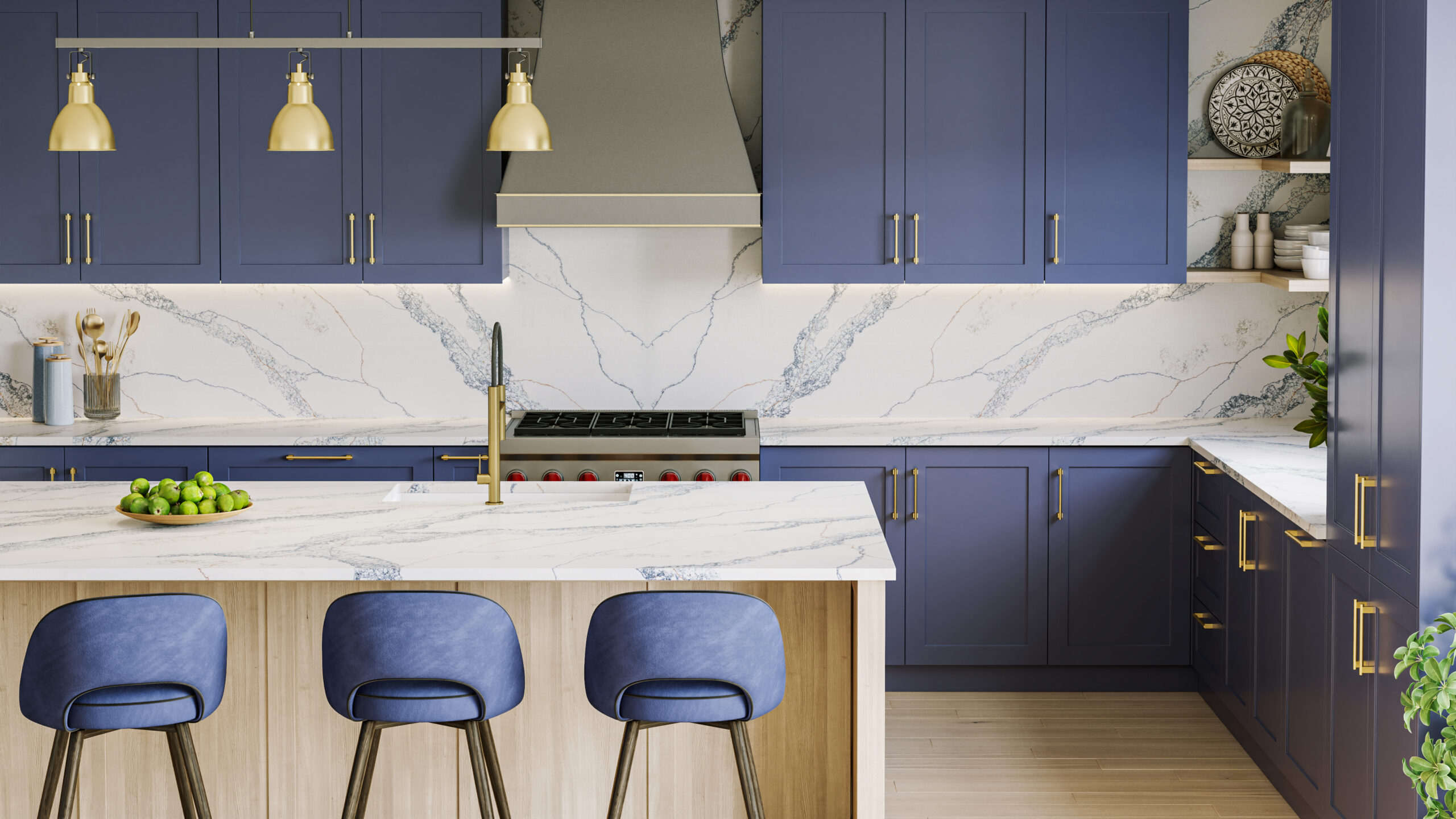 Modern kitchen with deep blue cabinetry and matching blue countertops, accented by gold hardware and pendant lights. The space features a large island with a white and blue-veined quartz surface, sleek built-in appliances, and marble-style backsplash for a clean, luxurious look.