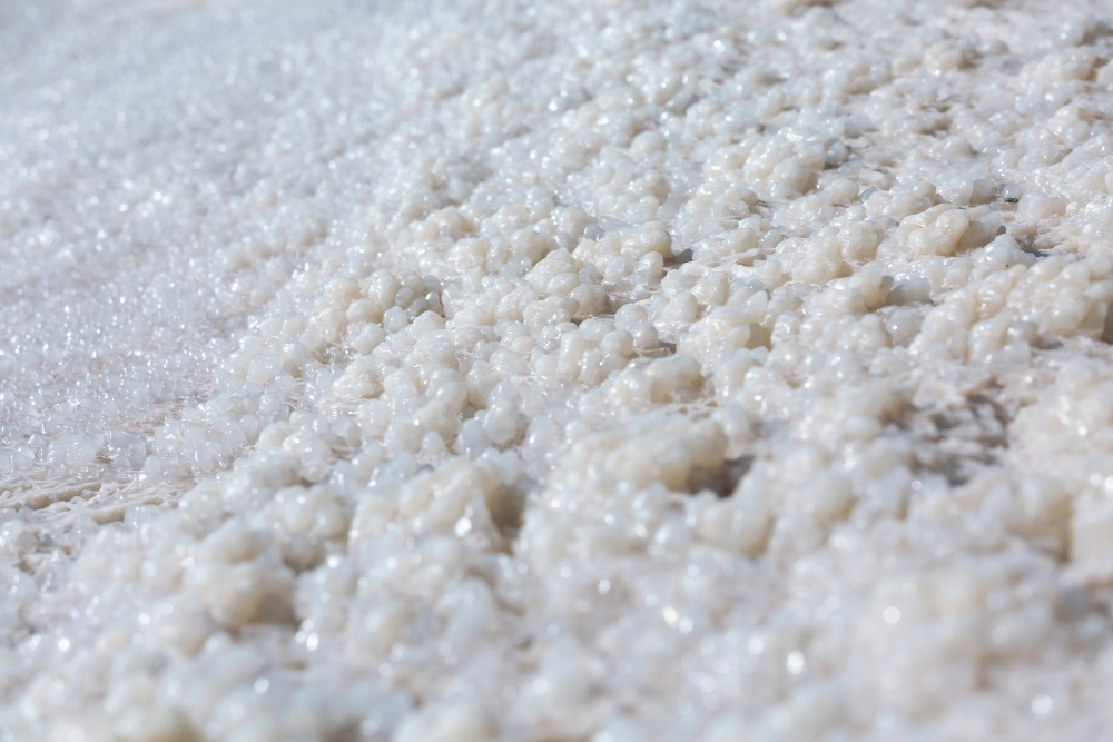 White translucent plastic resin pellets scattered across industrial surfac