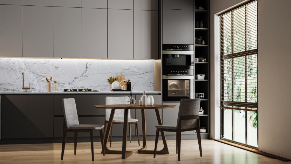 Modern gray kitchen with white marble backsplash, wood table & chairs, and large window blinds.